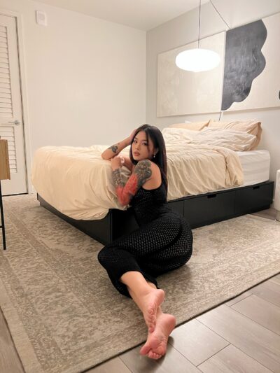 Feet of tattooed Asian woman on the floor